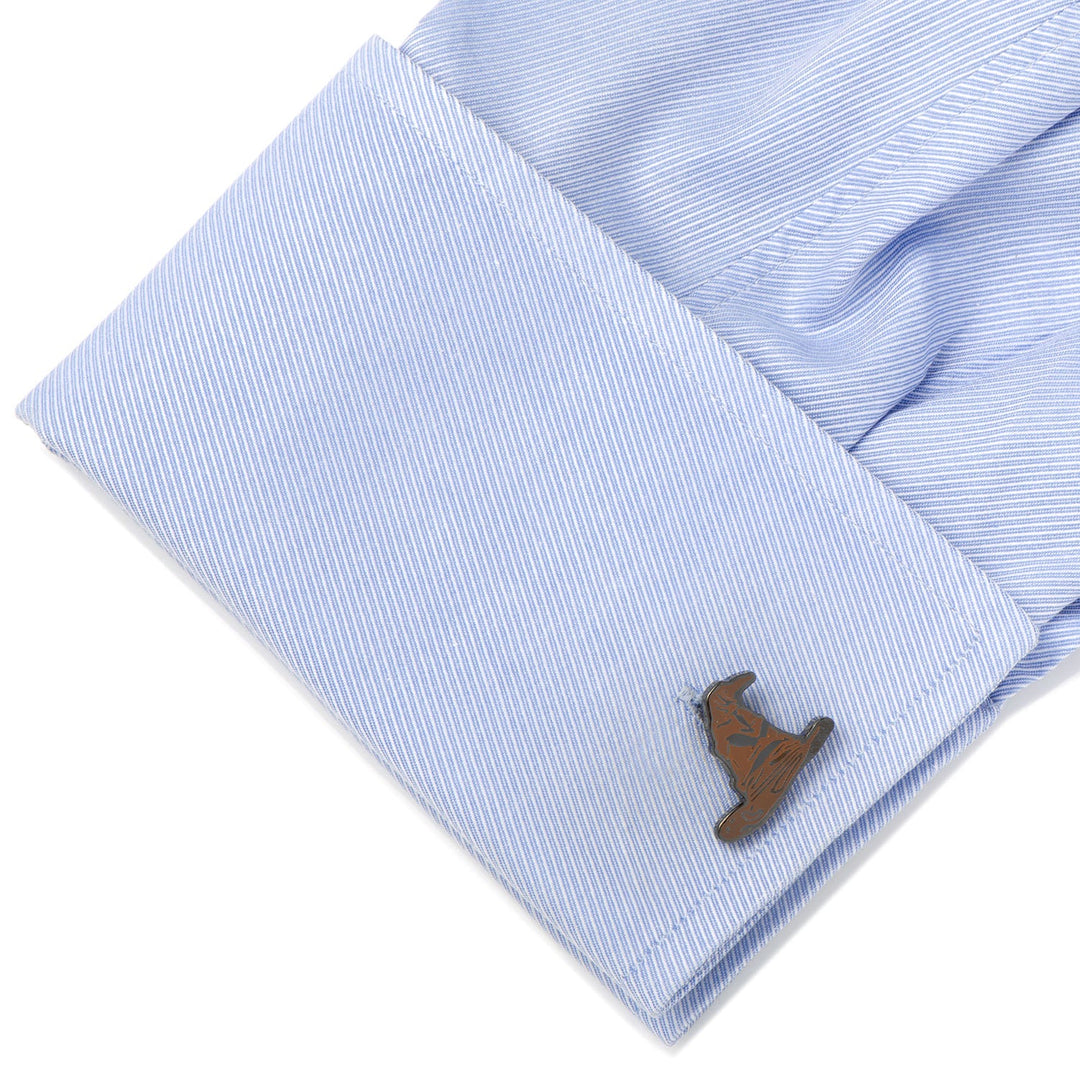 A metal Harry Potter Sorting Hat Cufflinks piece attached to a light blue dress shirt cuff.