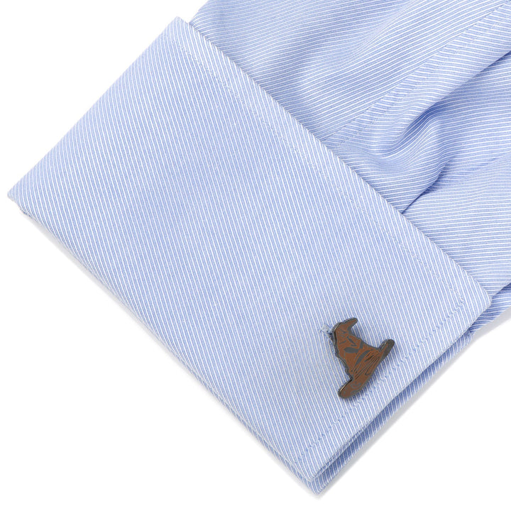 A metal Harry Potter Sorting Hat Cufflinks piece attached to a light blue dress shirt cuff.
