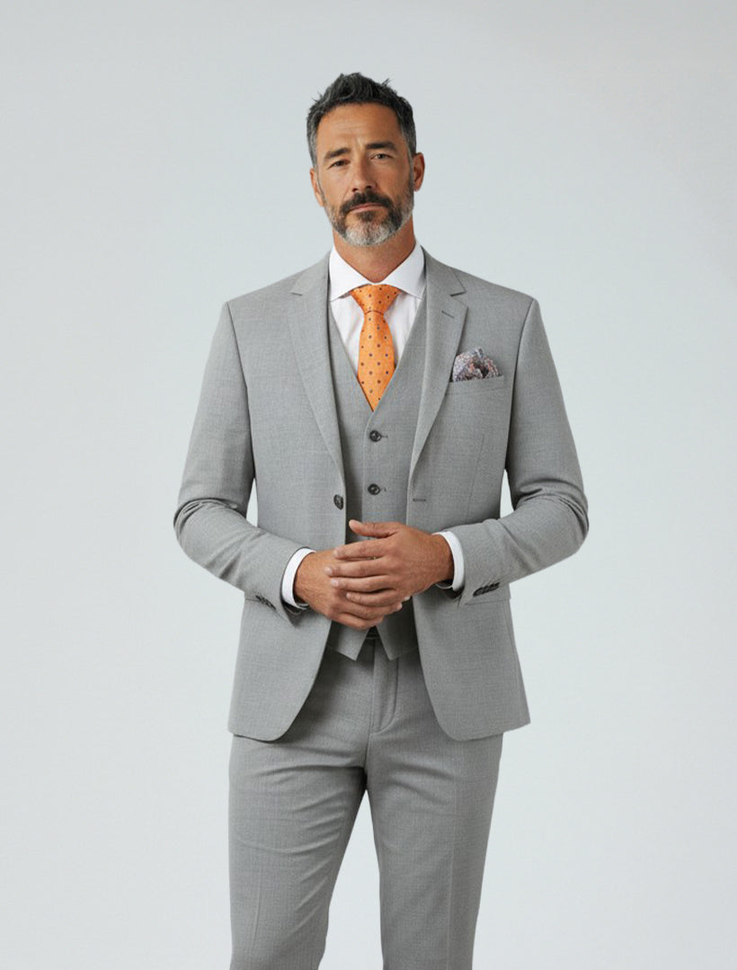 A man with short dark hair and a beard is wearing the Light Grey Men's Slim-Fit Suit Separates Jacket by Karako Separate, paired with a white shirt and orange tie, standing against a plain light background.