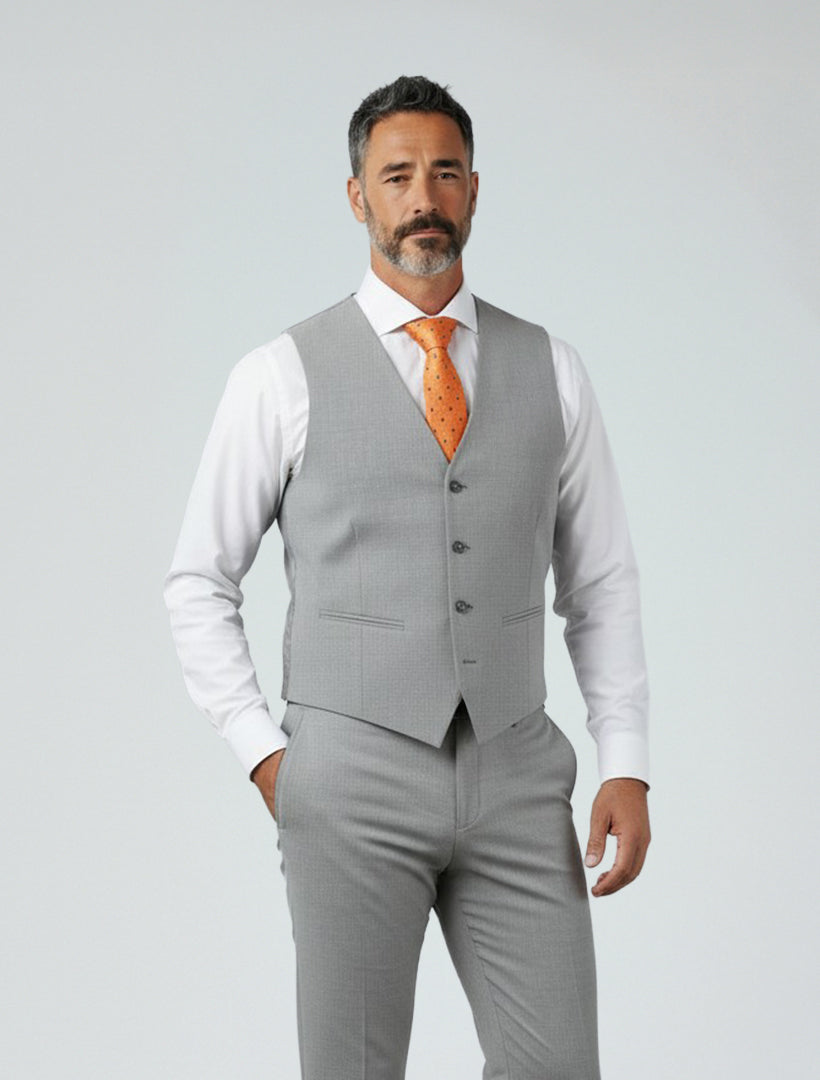 A man wears the Light Grey Men's Slim-Fit Suit Separates Vest by Karako Separate with matching trousers, a white dress shirt, and an orange tie, standing against a plain light background.