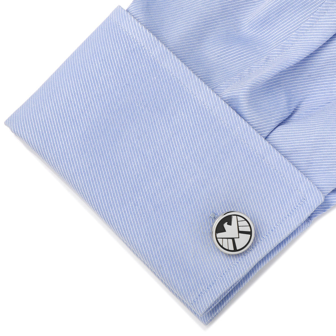 Round silver Marvel Agents of S.H.I.E.L.D. Cufflinks with a black and white eagle logo on a light blue dress shirt cuff.