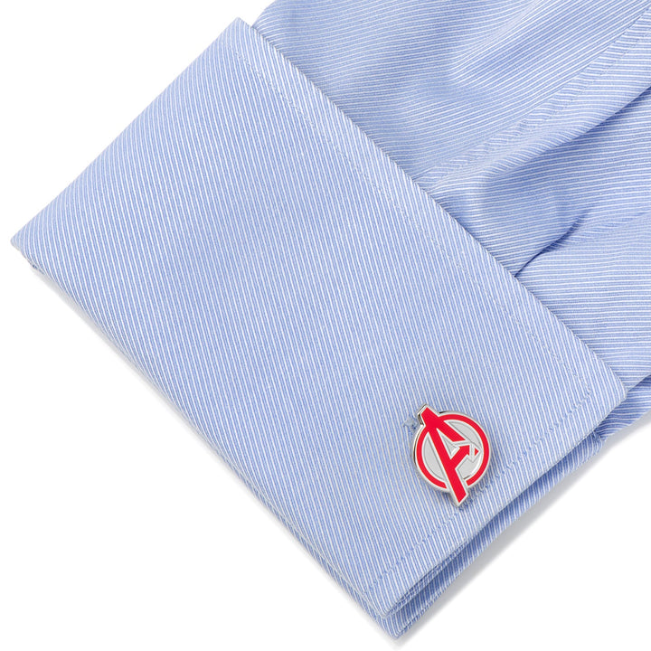 A light blue striped shirt cuff fastened with Marvel Avengers Cufflinks featuring a silver and red circular emblem with a stylized letter A.
