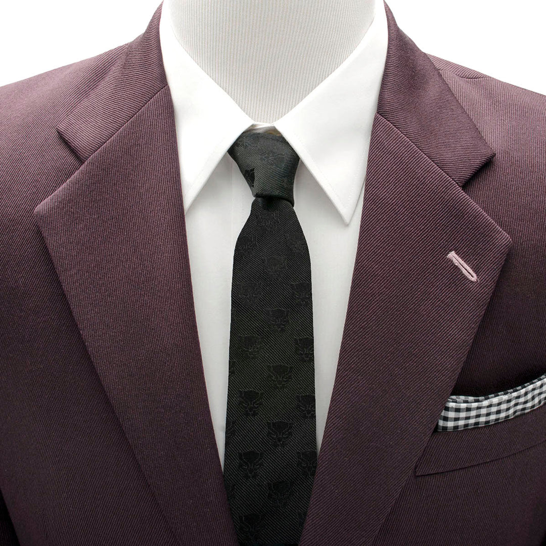 Marvel Black Panther Men’s Tie featuring a repeating pattern of panther masks, worn with a white shirt and dark purple suit jacket.