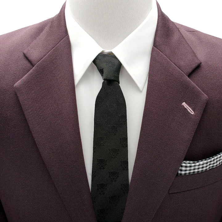 Marvel Black Panther Men’s Tie featuring a repeating pattern of panther masks, worn with a white shirt and dark purple suit jacket.