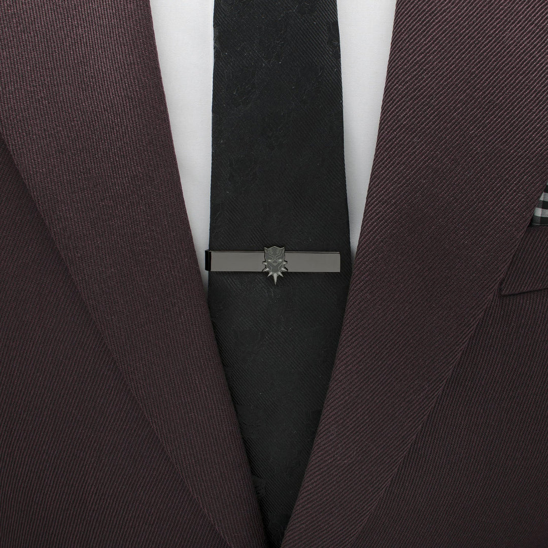 Marvel Black Panther Tie Bar in black metal featuring a mask icon, worn on a black tie and a dark suit jacket.