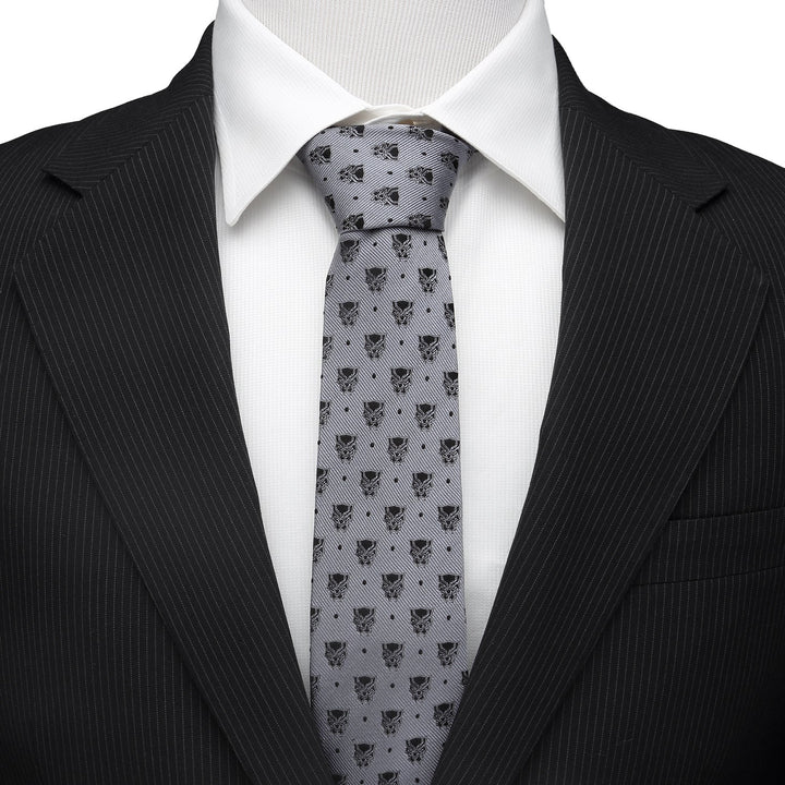 Marvel Black Panther Gray Dot Tie in gray silk with a repeating mask pattern, worn with a white shirt and black pinstripe suit jacket.