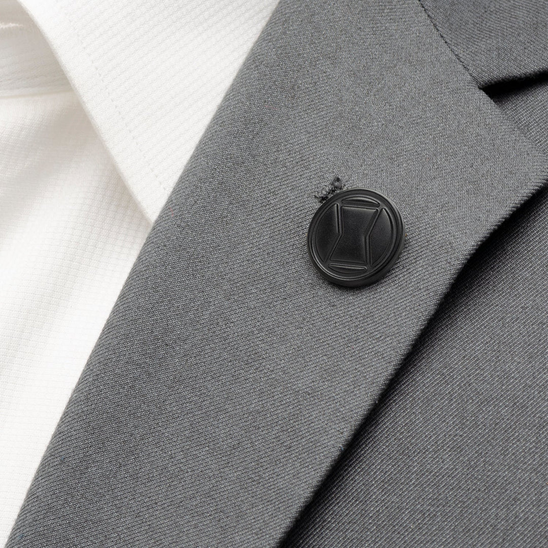 Round black Marvel Black Widow Lapel Pin attached to a gray suit jacket lapel over a white shirt.