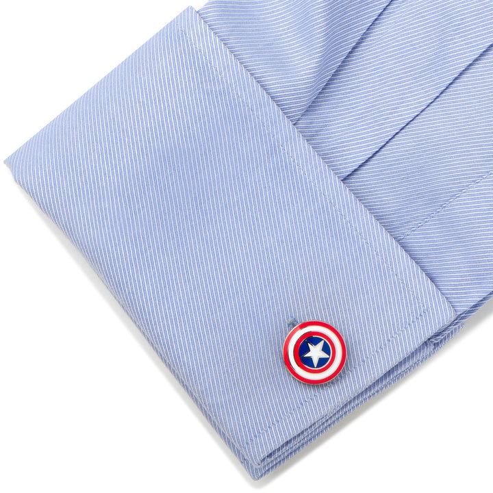 A circular Marvel Captain America Shield Cufflink featuring a red, white, and blue star design, fastened to a light blue dress shirt cuff.