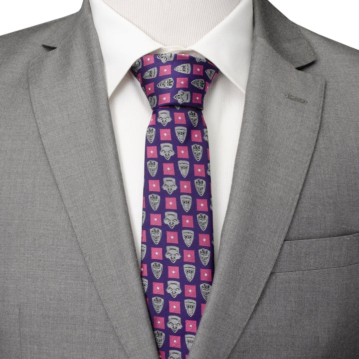A Marvel Guardian’s of the Galaxy Purple Men’s Tie featuring a repeating pattern of gray mask icons and pink squares, worn with a white dress shirt and gray suit jacket.
