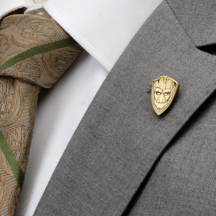 Gold-toned, shield-shaped Marvel Guardians of the Galaxy Groot Lapel Pin featuring the face of Groot, attached to a grey suit jacket.