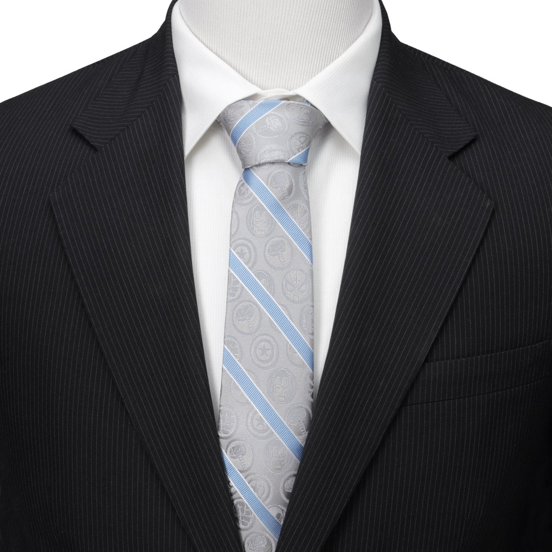 Marvel Comics Gray and Blue Stripe Men’s Tie in gray with diagonal light blue stripes and subtle superhero icons, worn with a white dress shirt and black pinstripe suit jacket.