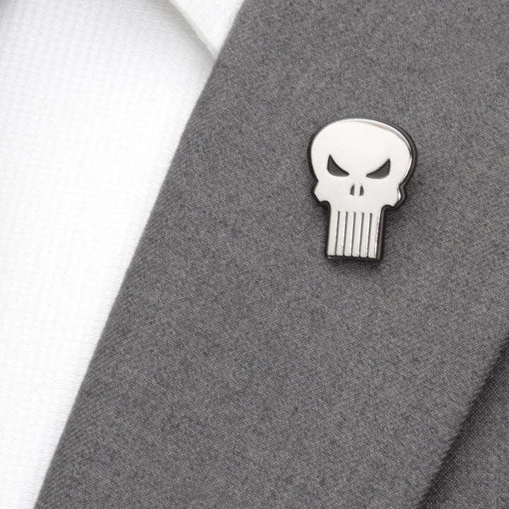 A silver Marvel The Punisher Silver Lapel Pin attached to a grey suit jacket lapel.