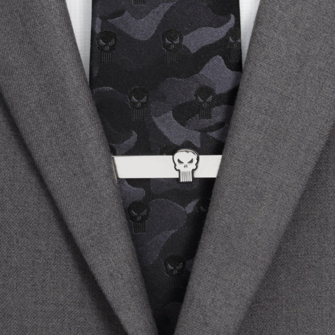 A silver Marvel The Punisher Silver Tie Bar worn on a dark camouflage tie and grey suit jacket.