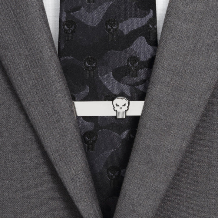 A silver Marvel The Punisher Silver Tie Bar worn on a dark camouflage tie and grey suit jacket.
