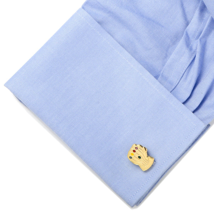Marvel Thanos Infinity Gauntlet cufflinks in gold-tone with colorful inset stones, attached to a light blue dress shirt cuff.