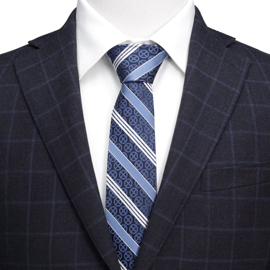A Marvel X-Men Symbol Navy Stripe Men’s Tie in navy and light blue silk with a repeating circular pattern, worn with a white dress shirt and a dark plaid blazer.