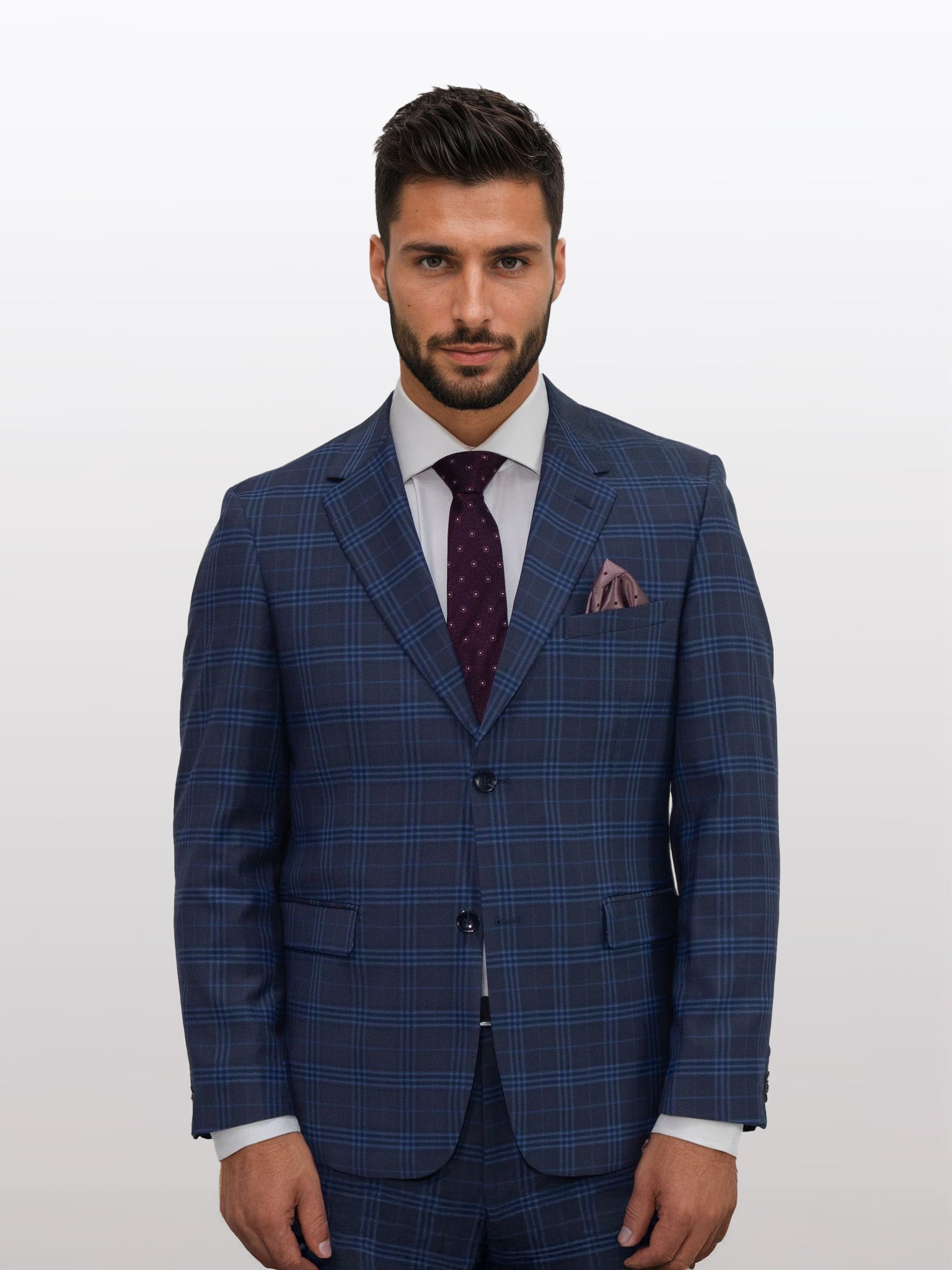 A man with a beard stands against a plain background, dressed in a Men's Charcoal with Navy Pattern Slim Fit Suit by Gianco Ferro, paired with a white shirt and maroon polka dot tie.