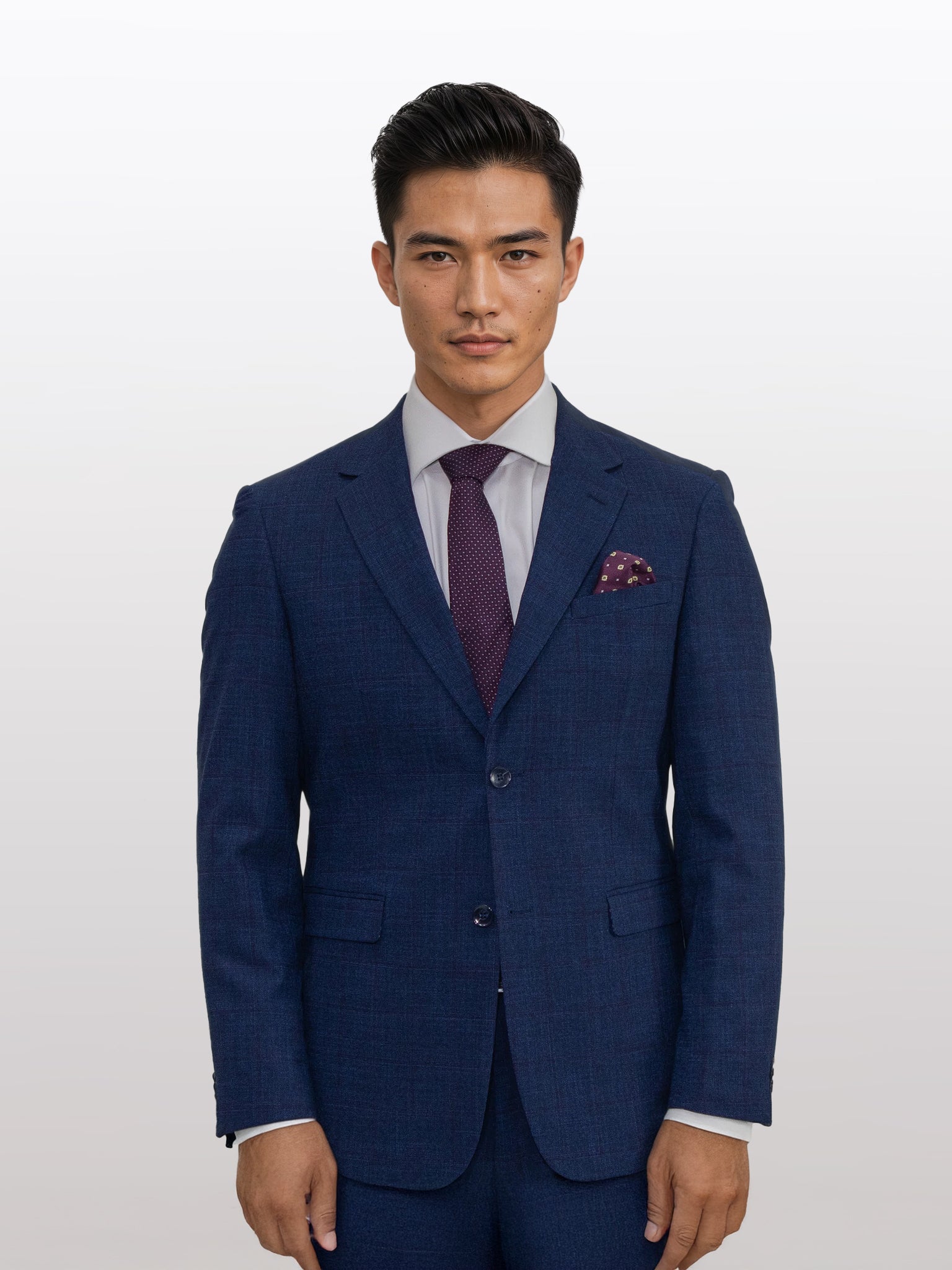 The man in a Gianco Ferro Men's Dark Blue with Red Windowpane Slim Fit Suit, paired with a white shirt and maroon tie, poses effortlessly against a plain background.