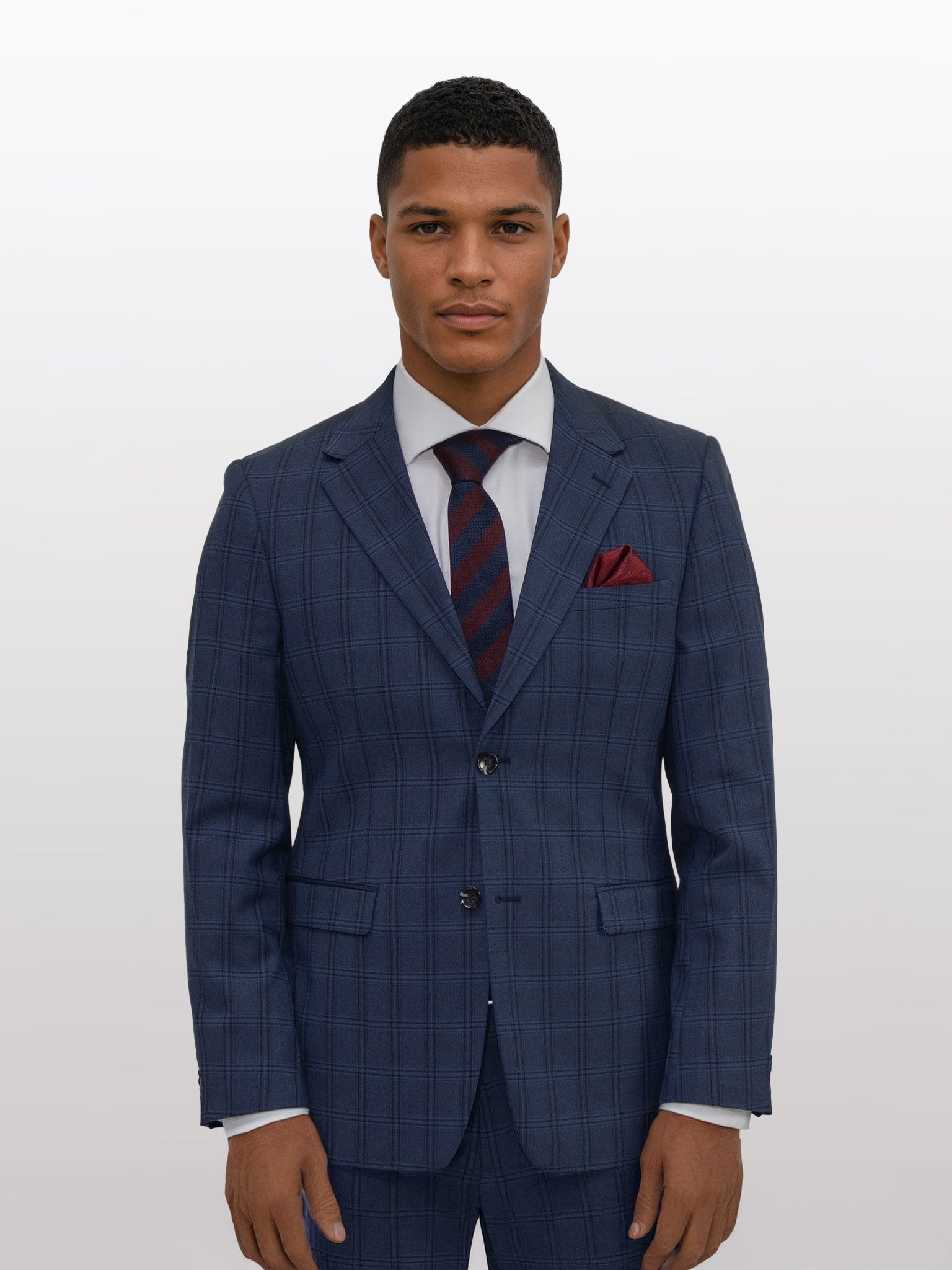 A person in a dark blue with black double windowpane slim fit suit by Gianco Ferro, accessorized with a red pocket square, poses confidently against a plain background.