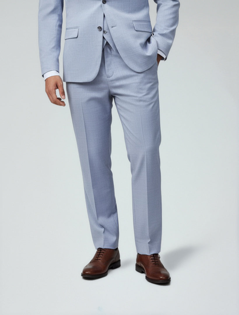 A person wears Couture 1910 Men's Light Blue Dress Pants with a white shirt and brown dress shoes, standing against a plain background.