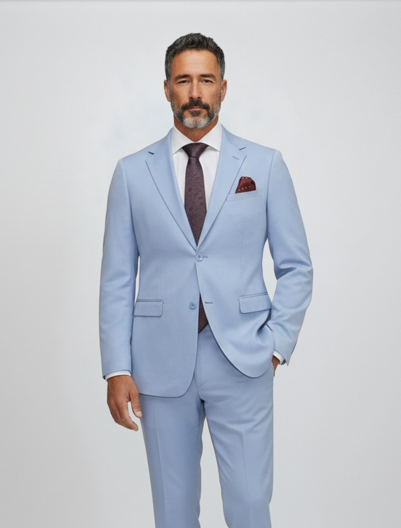 A man with short dark hair and a beard is wearing the Gianco Ferro Men’s Light Blue Solid Slim Fit Suit, styled with a crisp white shirt, burgundy tie, and matching pocket square, standing against a plain light background.