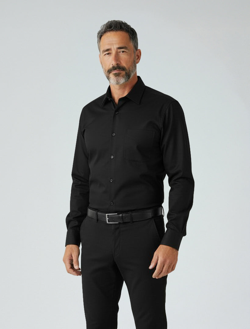 A man with short gray hair and a beard is wearing the Karako Men Black Dress Shirt by Karako Men and black pants, standing against a plain light background.