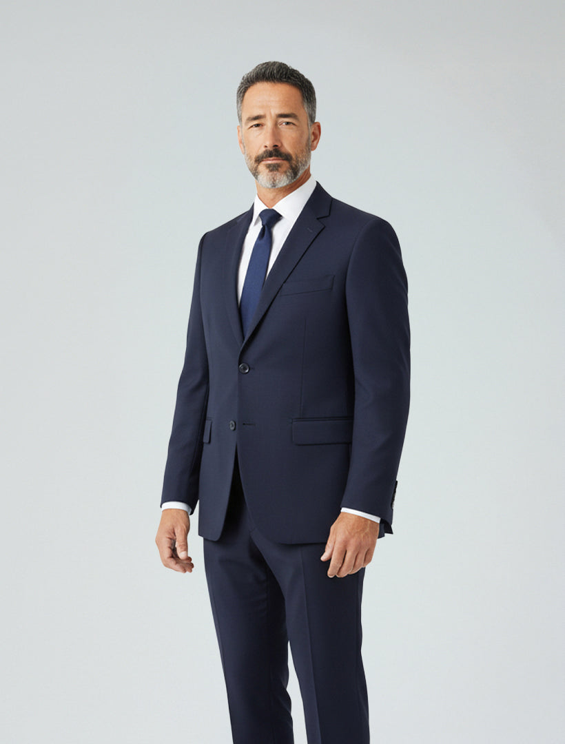 A man wears the Karako Men Mens Navy Suit with a white dress shirt and dark tie, standing against a plain light background and looking at the camera with a neutral expression.