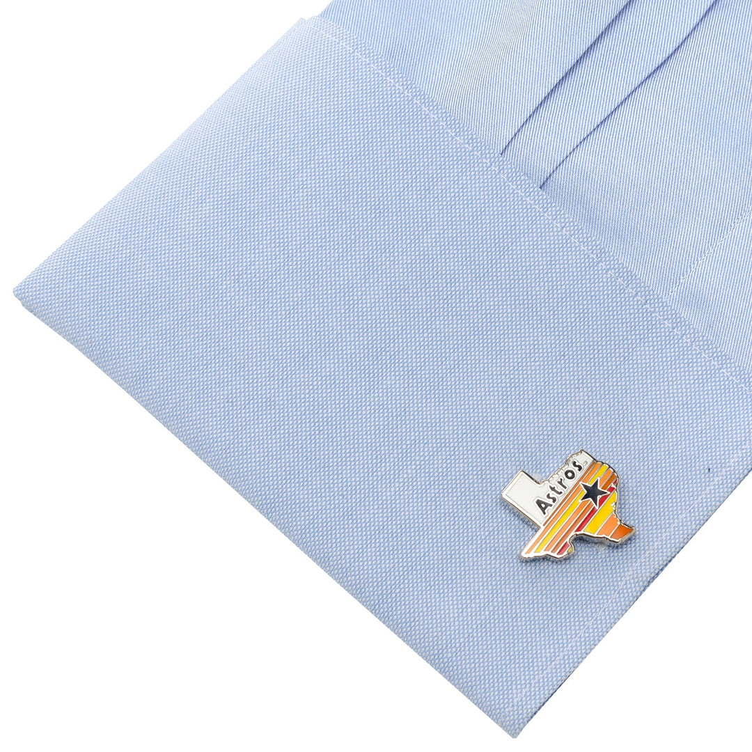 A pair of MLB Houston Astros Tequila Sunrise Cufflinks shaped like the state of Texas attached to a light blue dress shirt cuff.