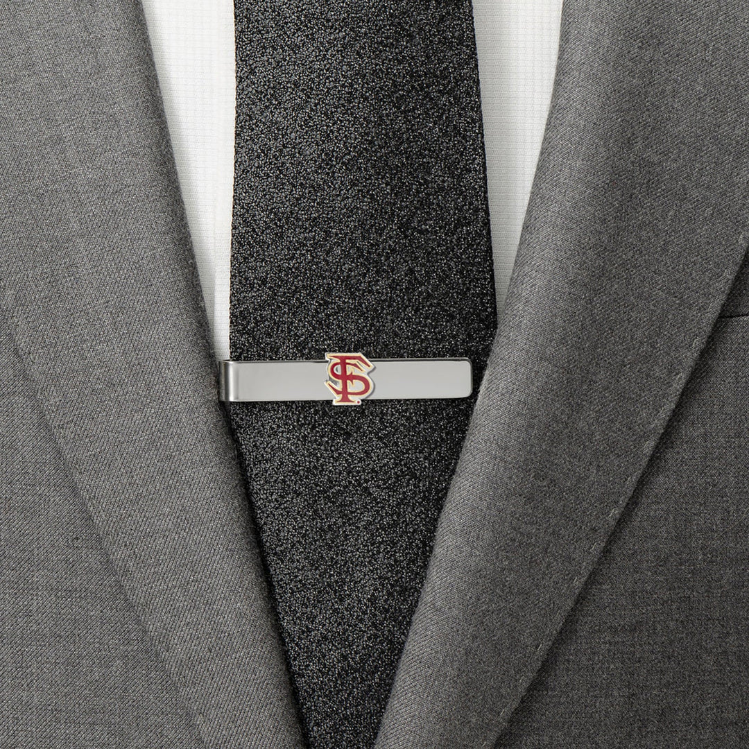 A silver NCAA Florida State Seminoles Tie Bar featuring the garnet and gold logo, clipped to a black tie and grey suit jacket.
