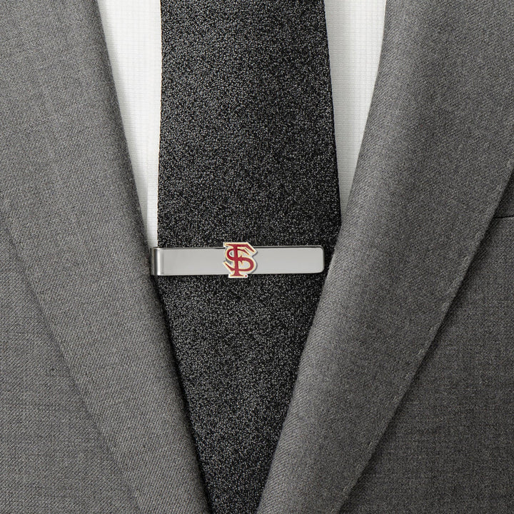 A silver NCAA Florida State Seminoles Tie Bar featuring the garnet and gold logo, clipped to a black tie and grey suit jacket.