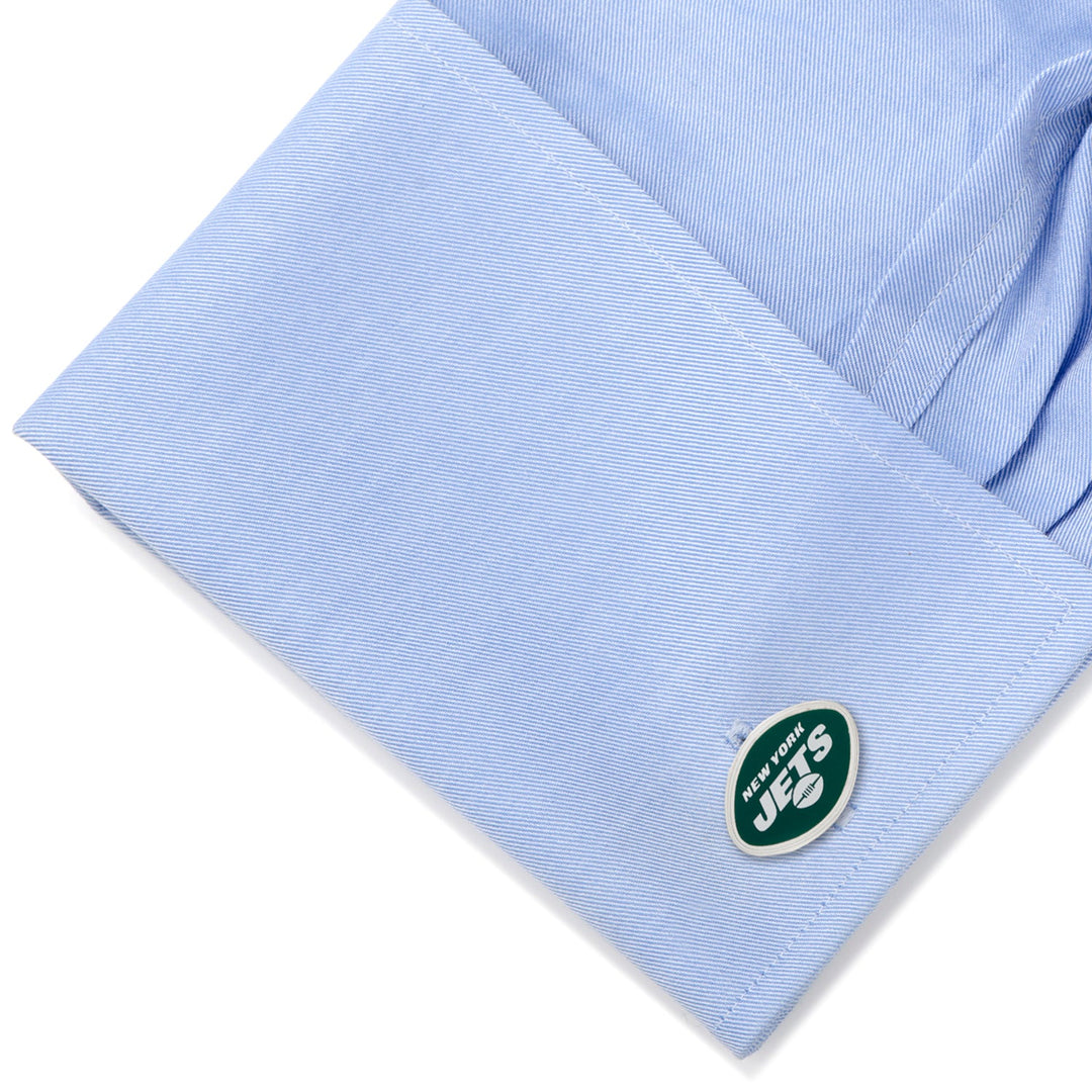 Oval-shaped NFL New York Jets Cufflinks featuring the team logo, attached to a light blue dress shirt cuff.