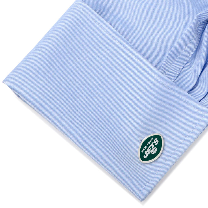 Oval-shaped NFL New York Jets Cufflinks featuring the team logo, attached to a light blue dress shirt cuff.