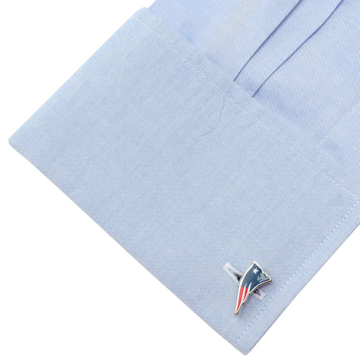 A light blue dress shirt cuff fastened with NFL New England Patriots Cufflinks.