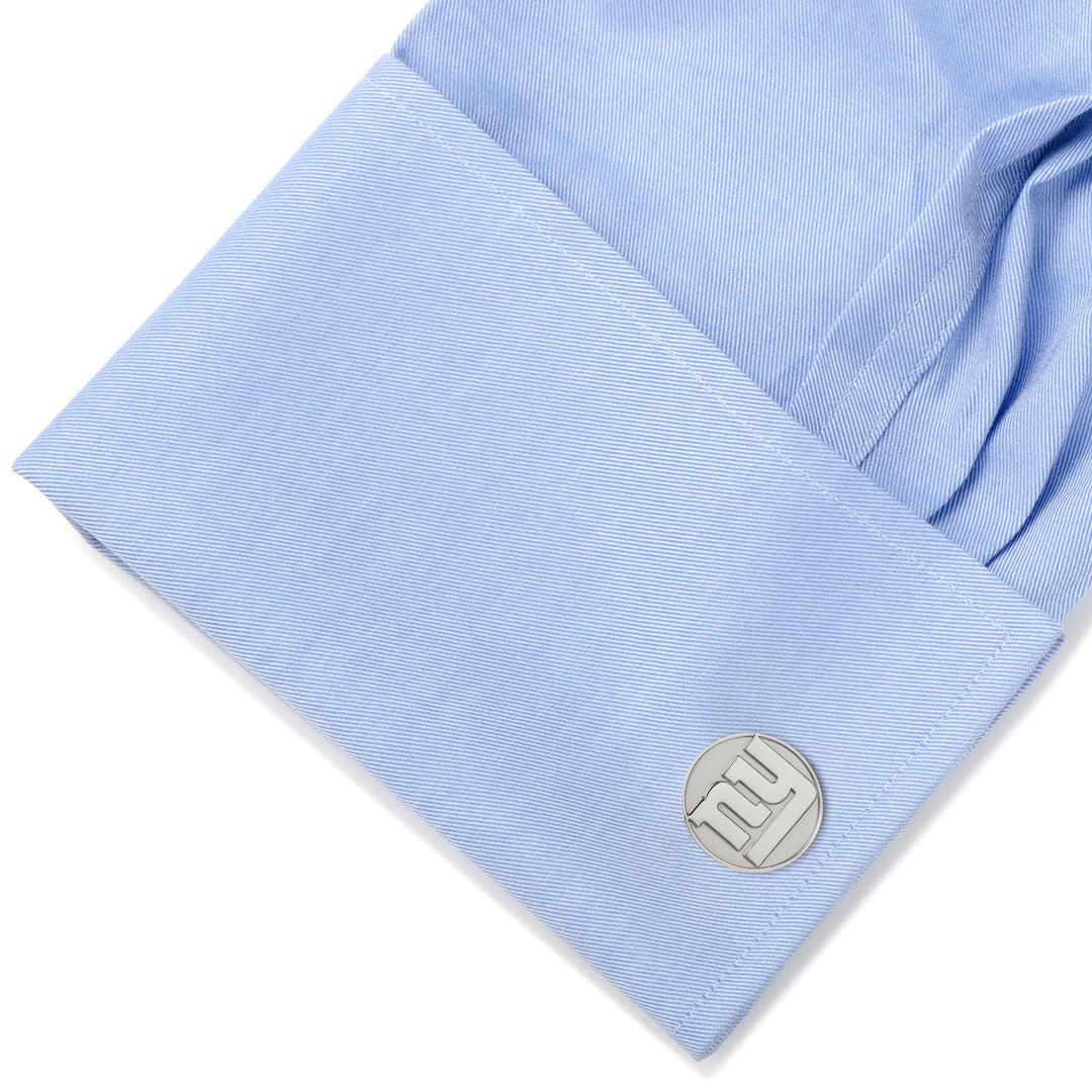 Round silver NFL New York Giants Silver Edition cufflinks on a light blue dress shirt cuff.