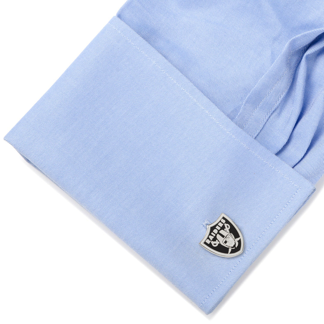 Light blue shirt cuff fastened with a shield-shaped NFL Las Vegas Raiders Cufflinks.