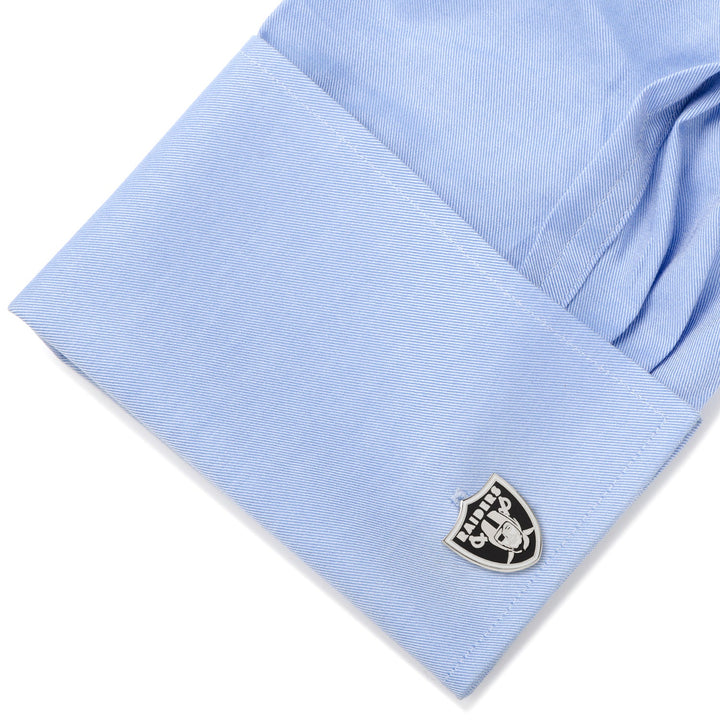 Light blue shirt cuff fastened with a shield-shaped NFL Las Vegas Raiders Cufflinks.