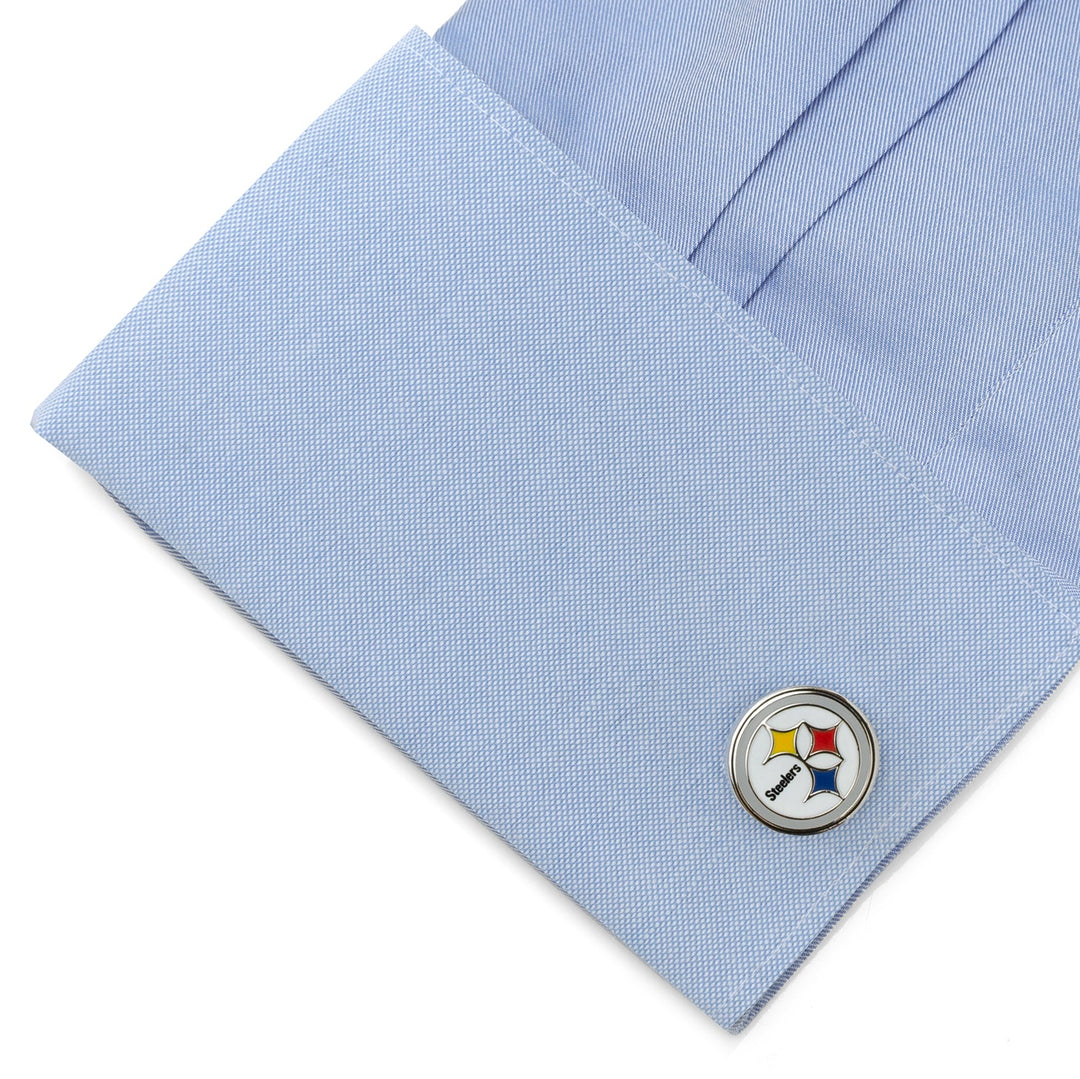 A circular silver NFL Pittsburgh Steelers Cufflinks attached to a light blue dress shirt cuff.
