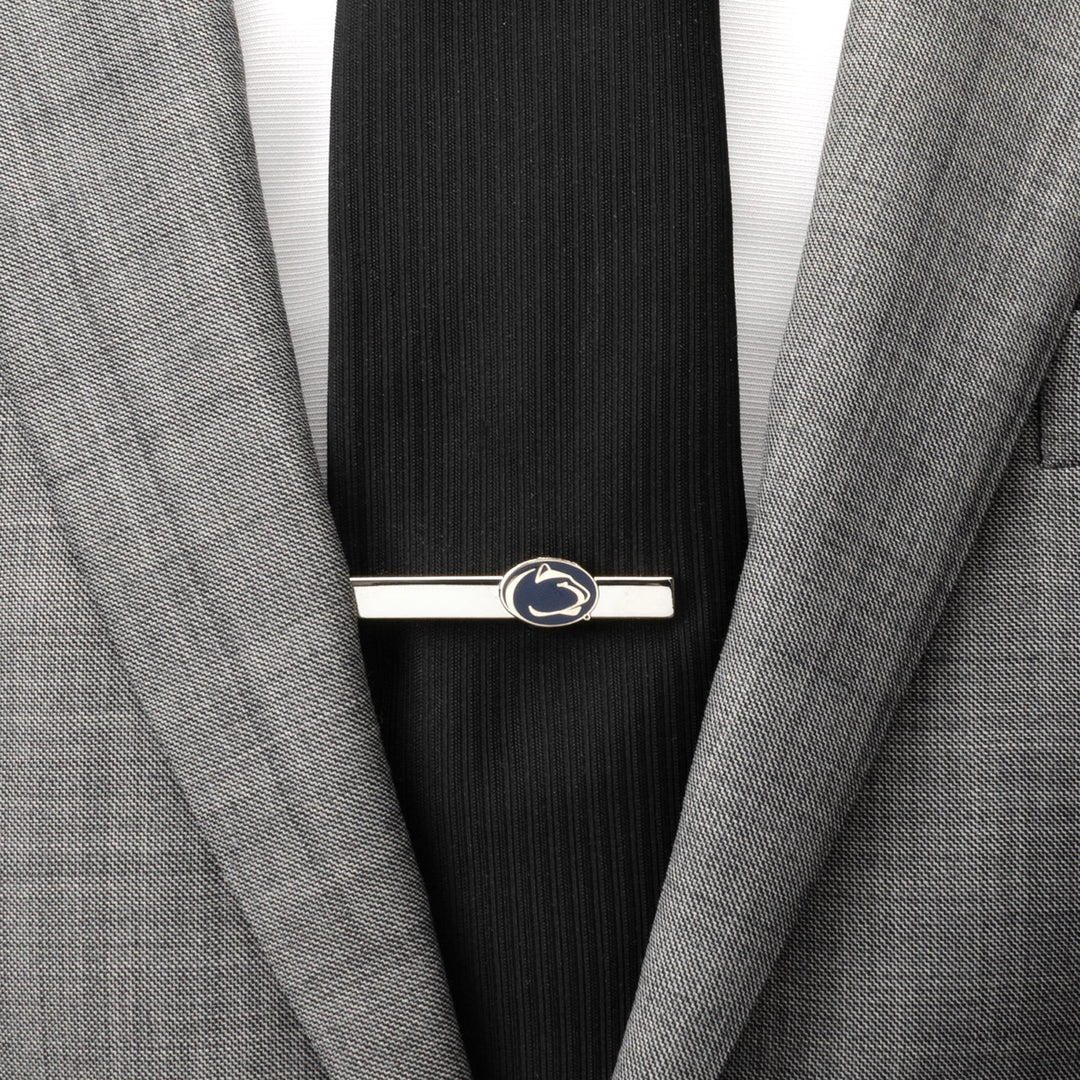 Silver NCAA Penn State University Nittany Lions Tie Clip featuring a blue and white mountain lion head logo, attached to a black tie and grey suit jacket.