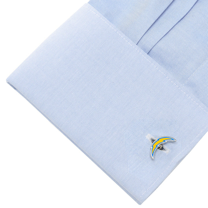 A light blue dress shirt cuff fastened with silver NFL Los Angeles Chargers Cufflinks.