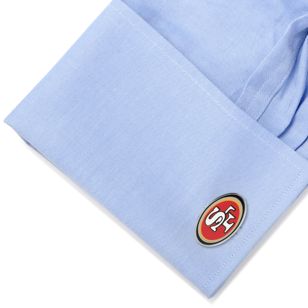 Oval NFL San Francisco 49ers Cufflinks attached to a light blue dress shirt cuff.
