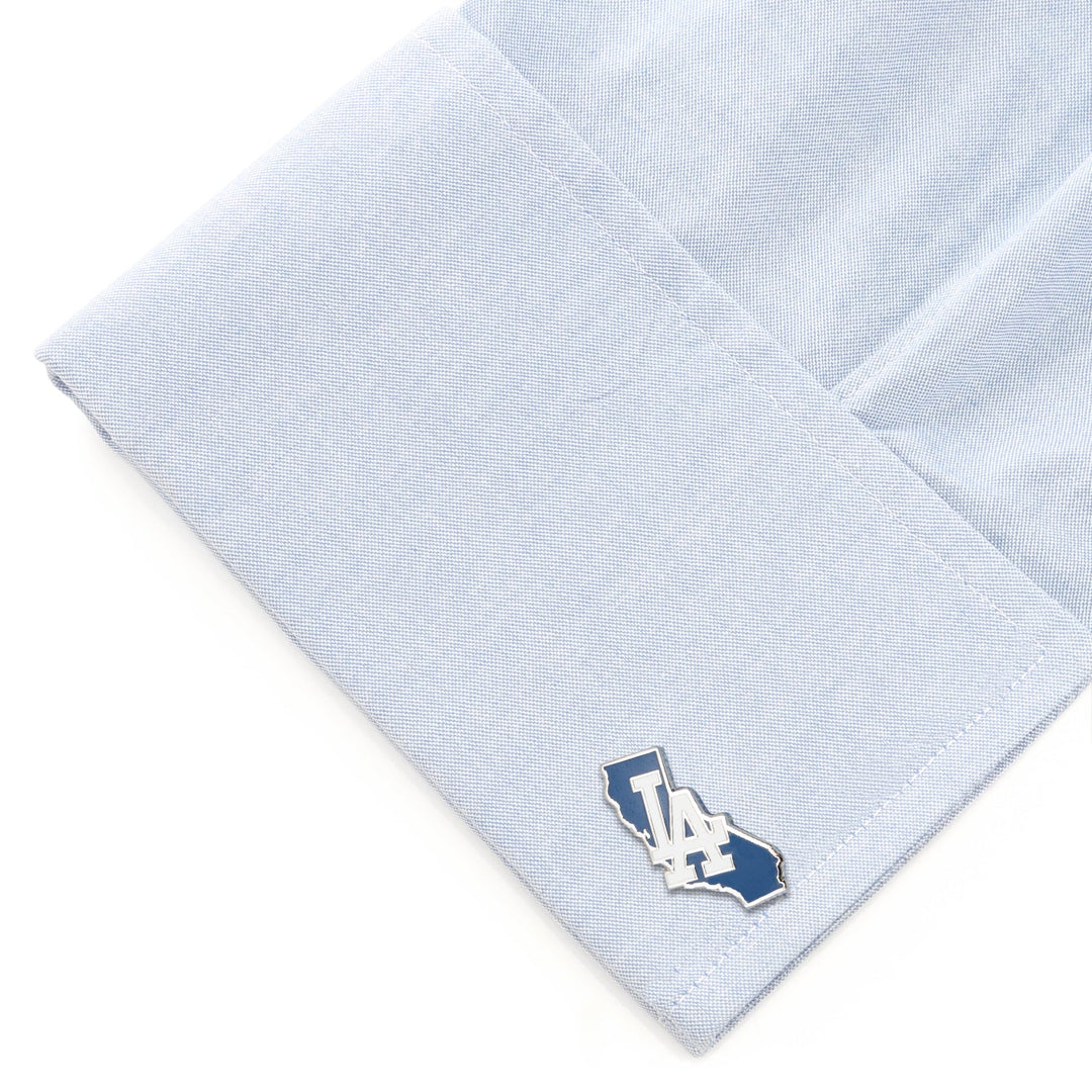 MLB LA Dodgers State Shaped Cufflinks, a silver-toned California-shaped cufflink featuring an “LA” Dodgers logo, attached to a light blue dress shirt cuff.