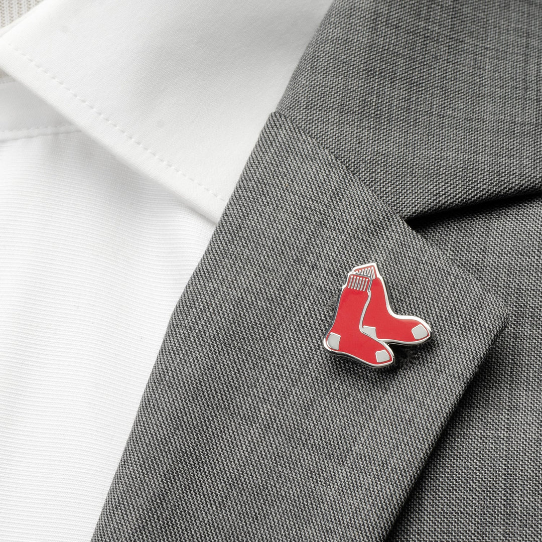 An MLB Boston Red Sox Lapel Pin shaped like a pair of red socks fastened to the lapel of a gray suit jacket.