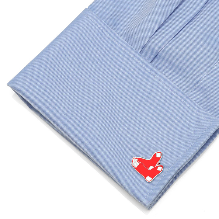 A red sock-shaped MLB Red Sox Cufflinks on a light blue dress shirt cuff.