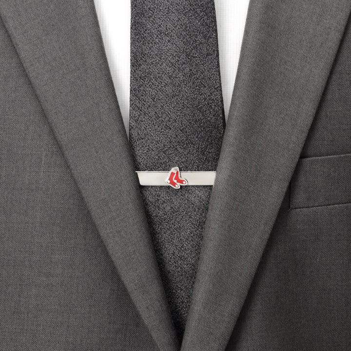 An MLB Boston Red Sox Tie Bar featuring a red sock logo, clipped onto a dark grey textured necktie and suit jacket.