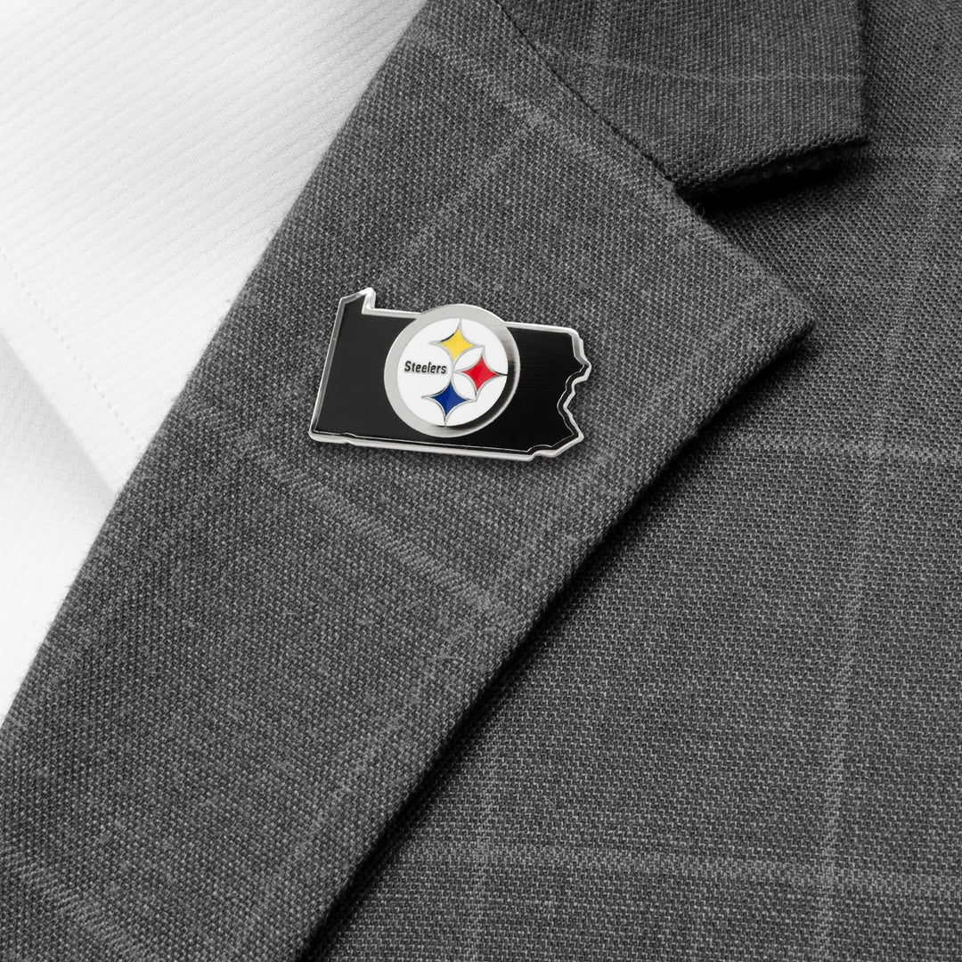 An NFL Pittsburgh Steelers State Shaped Lapel Pin shaped like the state of Pennsylvania attached to a gray suit jacket.