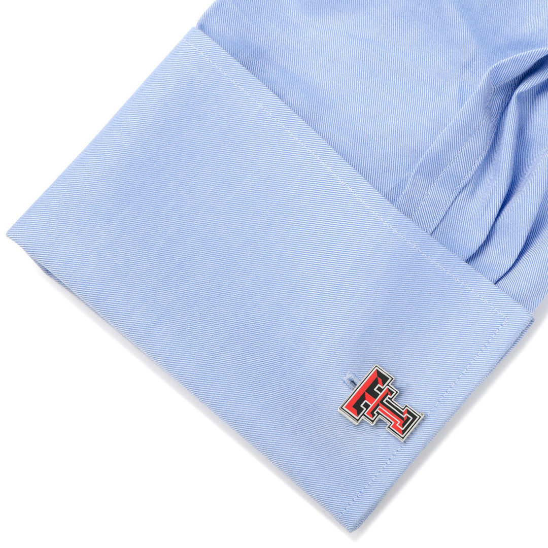A silver NCAA Texas Tech University Red Raiders cufflink fastened to a light blue dress shirt cuff.