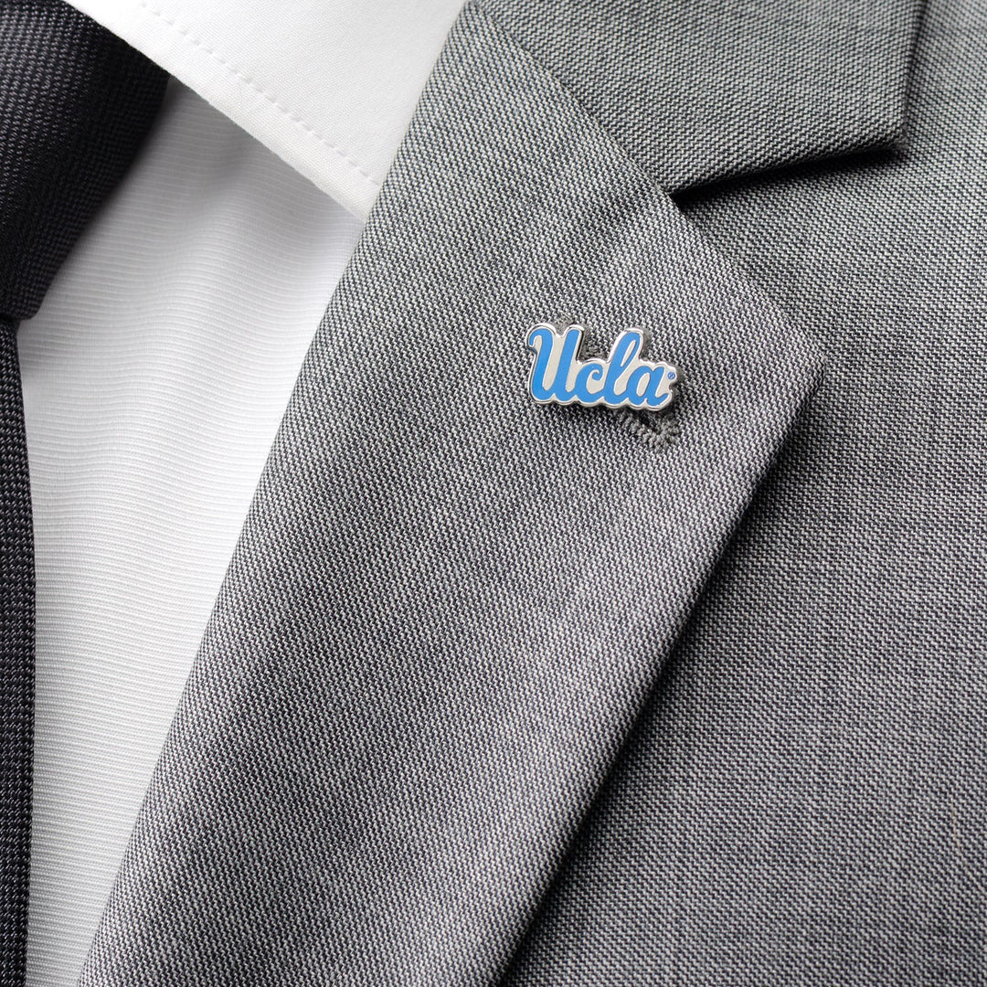 NCAA UCLA Bruins Lapel Pin in a script logo design attached to the lapel of a gray suit jacket.