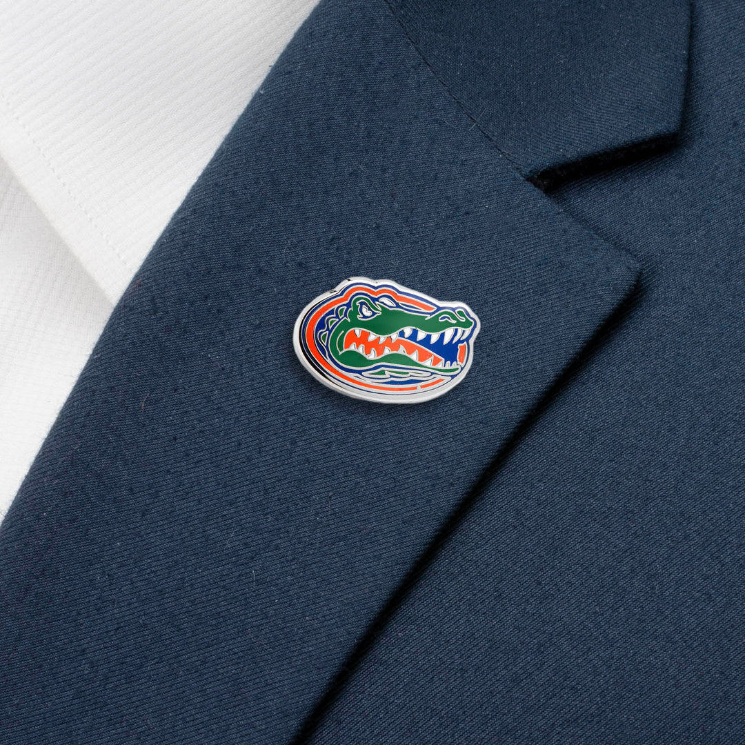 An NCAA University of Florida Gators Lapel Pin shaped like an orange, blue, and green alligator head, attached to a navy blue blazer lapel.