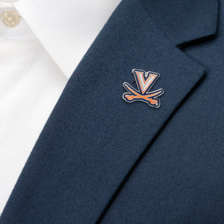 An NCAA University of Virginia Cavaliers Lapel Pin featuring a white letter V over two crossed orange and blue swords, pinned to a navy blue blazer.