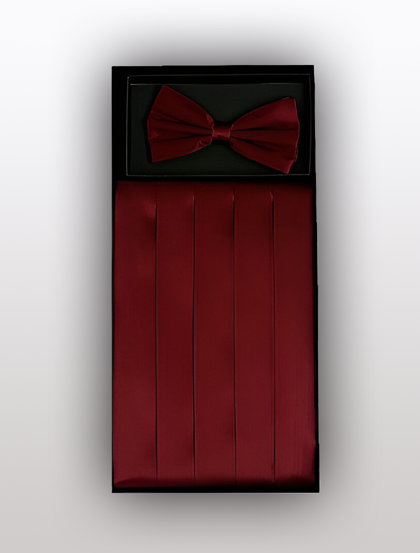 The Vesuvio Napoli Men's Silk Burgundy Cummerbund with Bow Tie set showcases a classic red design, expertly crafted from 100% silk and beautifully arranged against a white background.